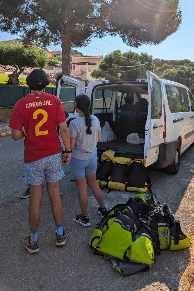Teilnehmer der Cova des Coloms Tour bereiten sich mit Ausrüstung und Neoprenanzügen auf das Höhlenabenteuer vor