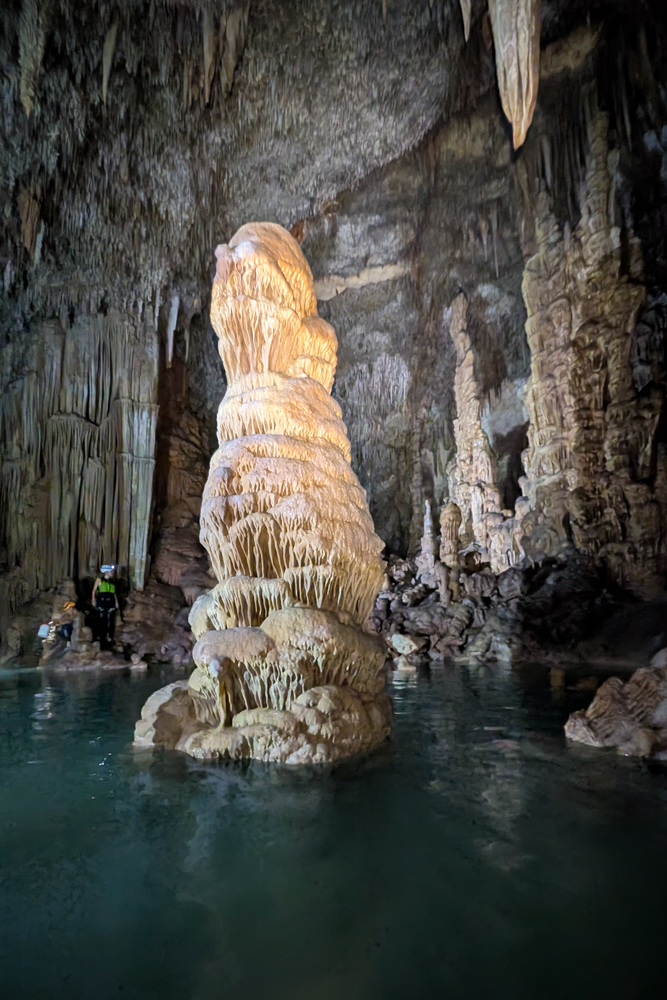 Eine beeindruckende Tropfsteinformation erhebt sich aus dem Wasser in der Cova des Coloms auf Mallorca